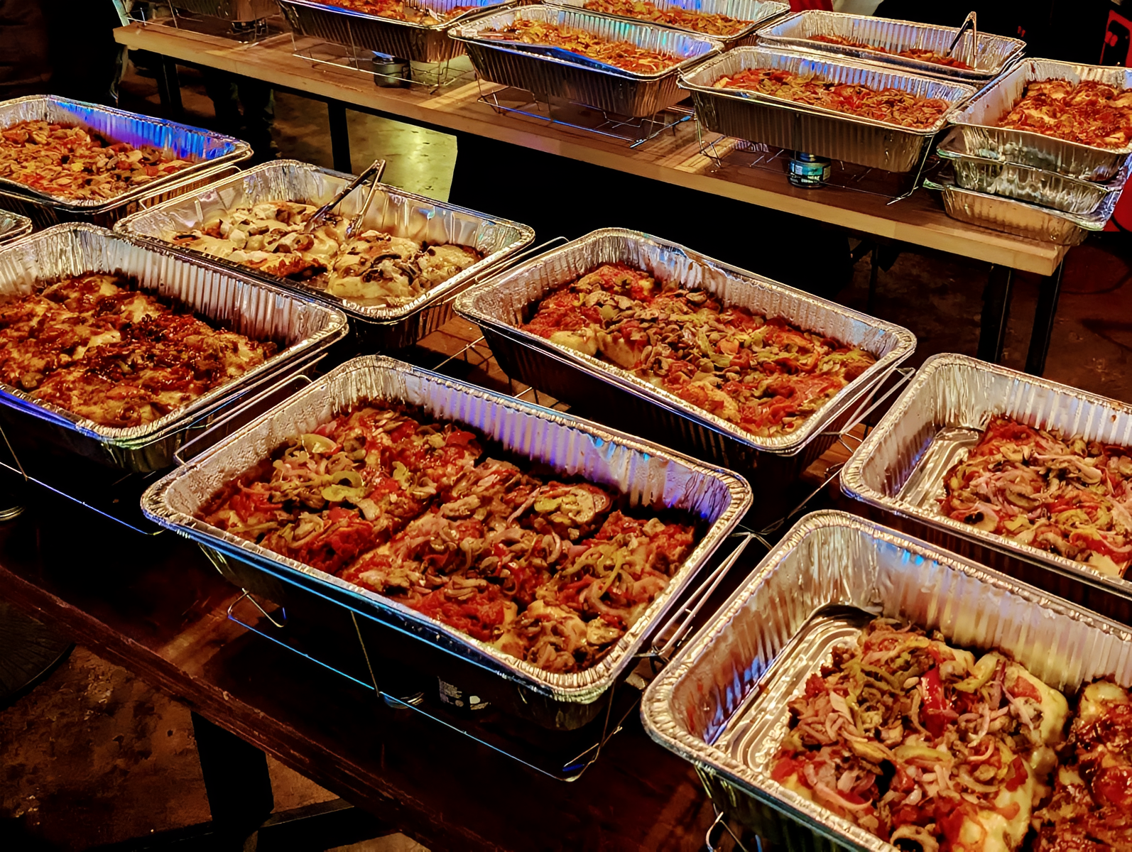 Metal trays filled with assorted pizzas