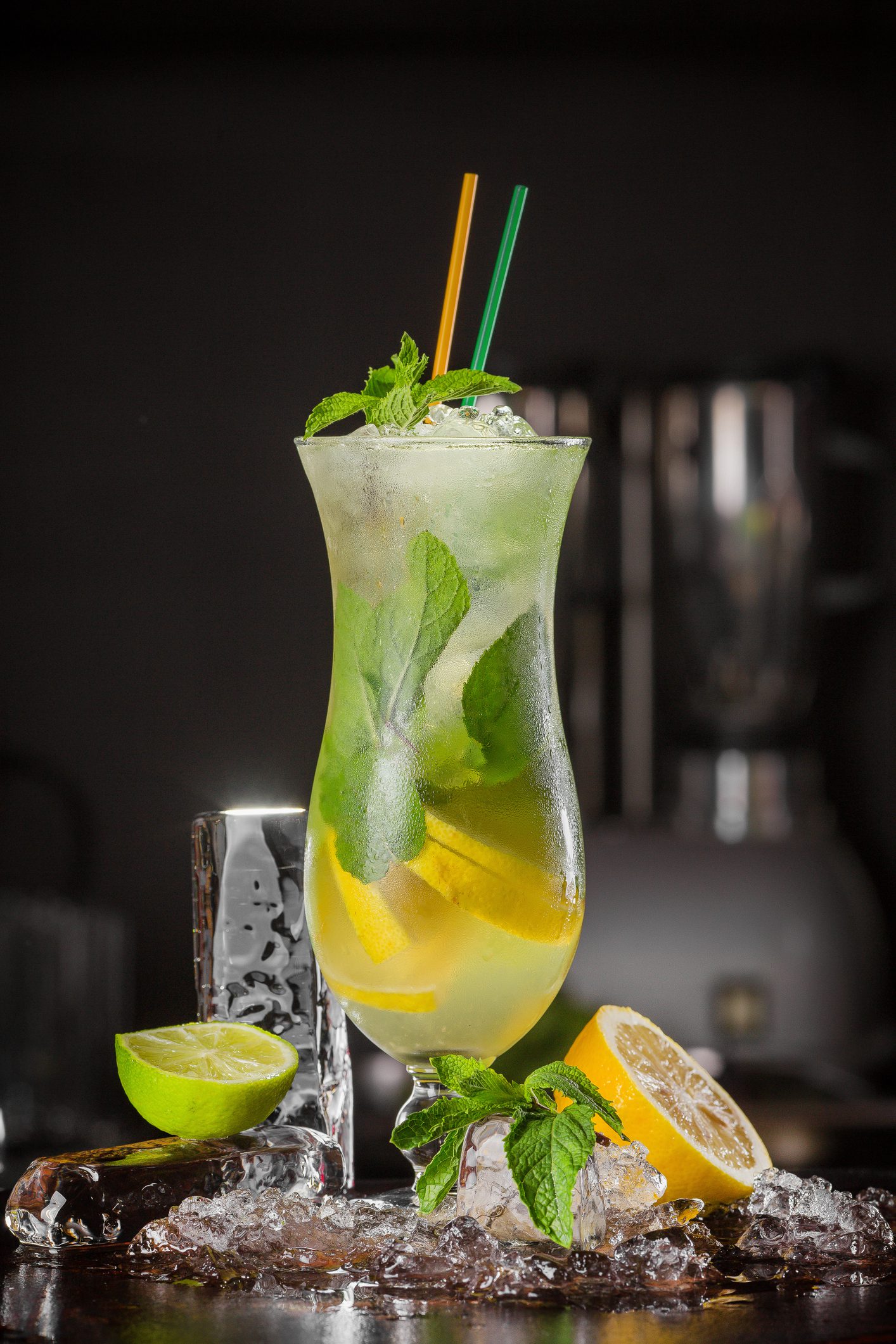 Color cocktail drink with fruits and ice cubes on black background