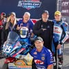 Team posing with motorcycle and award