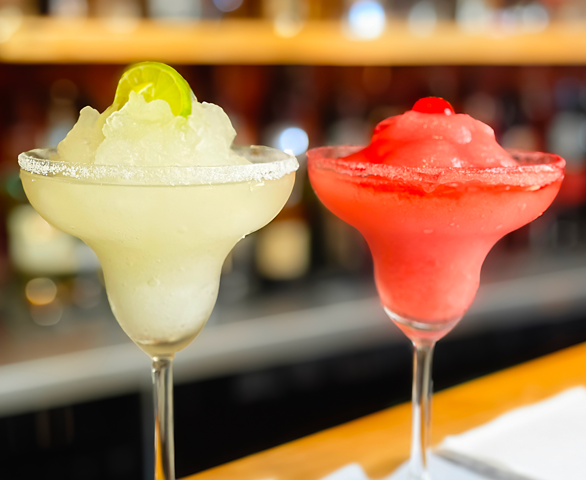 Colorful frozen cocktails on a bar counter